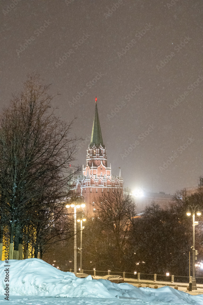 Moscow, Russia - December 27, 2022: Tower of the Moscow Kremlin. Cold and deserted Moscow street on a snowy winter evening near Red Square