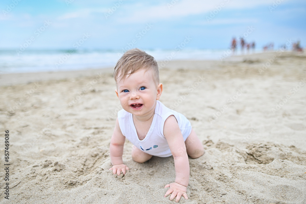 Happy child playing with sand at the beach in summer Happy child playing with sand at the beach in summer