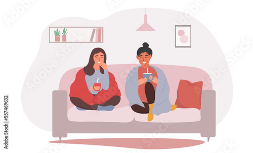Two girls to a friend are sitting on the couch in blankets and drinking a hot drink. Women at home communicate in a cozy interior. Vector graphics.