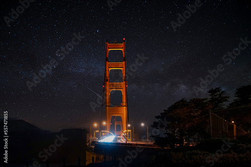 Illuminated light trails and streetlights on historic Golden Gate Bridge with beautiful star field in the background at night in San Francisco photo