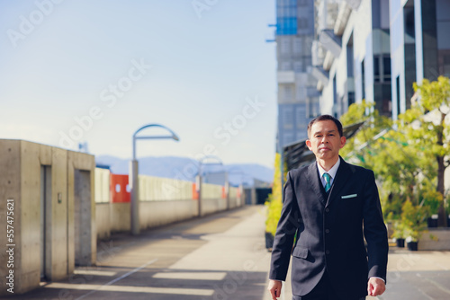 Middle-aged Asian man in black business suit at Kyoto station building, Japan. © DRN Studio