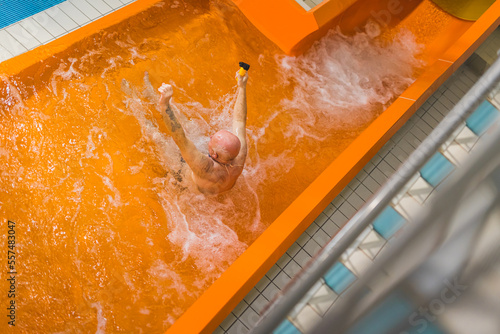 Senior man enjoying water sliding in aquapark. High quality photo photo