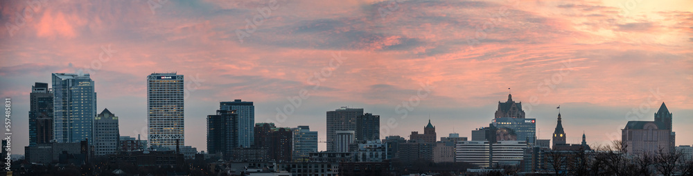 A panoramic view of the Milwaukee skyline with a magenta sky in the winter