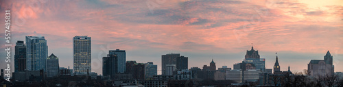 A panoramic view of the Milwaukee skyline with a magenta sky in the winter