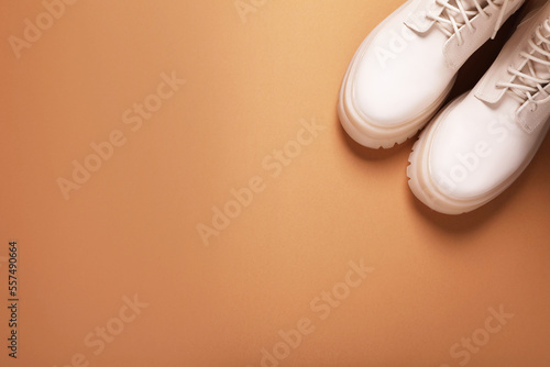 Pair of stylish leather shoes on light brown background, flat lay. Space for text