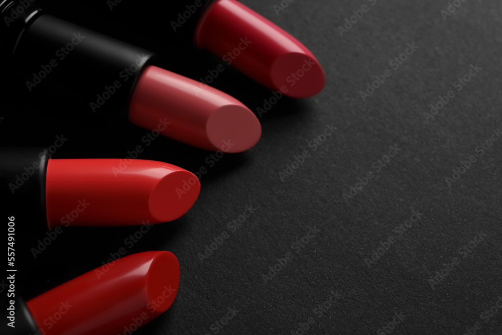 Beautiful lipsticks on black background, closeup. Space for text Beautiful lipsticks on black background, closeup. Space for text