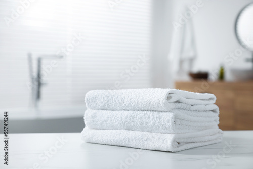 Stacked bath towels on white table indoors. Space for text