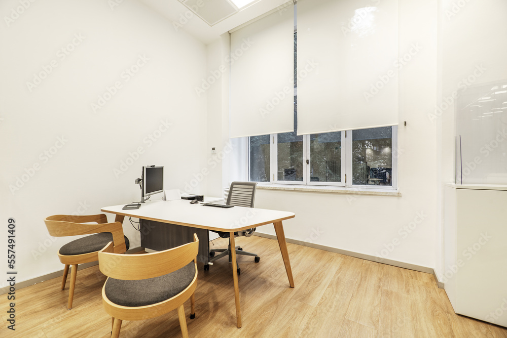 White office table with swivel chair, pc with screen on mast and wooden chairs for visitors White office table with swivel chair, pc with screen on mast and wooden chairs for visitors