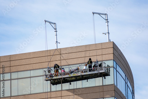 Картината върху платно Professional high rise window cleaning service workers in gondola