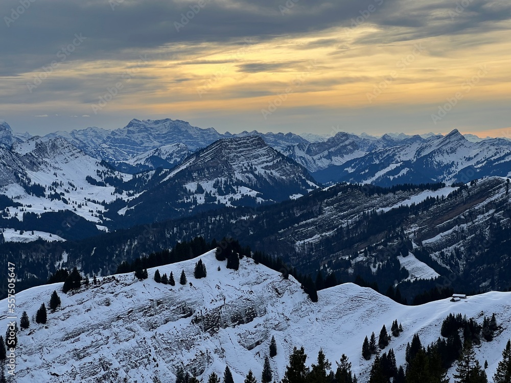 Fototapeta premium Magical sunset and shy sun behind winter clouds over the Obertoggenburg region and in the Swiss Prealps, Urnäsch (Urnaesch or Urnasch) - Canton of Appenzell Innerrhoden, Switzerland (Schweiz)