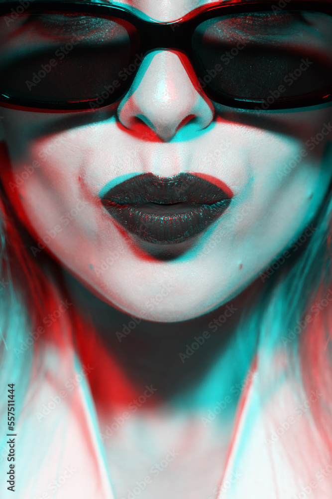 Fashion, make-up and lifestyle concept. Beautiful woman close-up studio portrait with sunglasses and lipstick making kiss facial expression in RGB color split effect. Futuristic looking style
