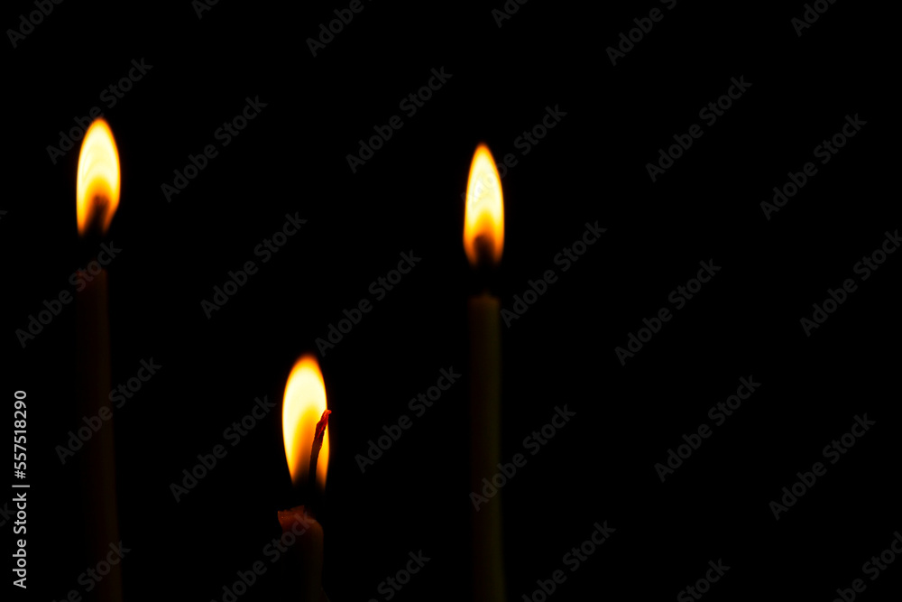 Three slim shape of Candle light of peace in the dark and yellow flame sue as peace elements, yoga. Three slim shape of Candle light of peace in the dark and yellow flame sue as peace elements, yoga.