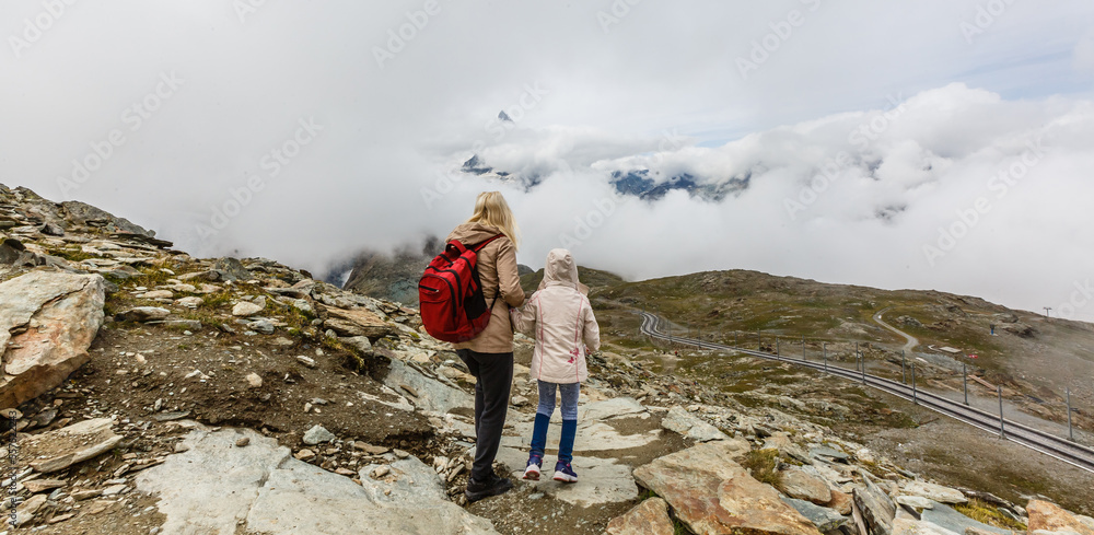 Mother and to children going for a walk in mountain surroundings