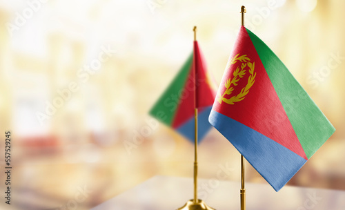 Small flags of the Eritrea on an abstract blurry background