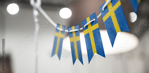 Canvas Print A garland of Sweden national flags on an abstract blurred background