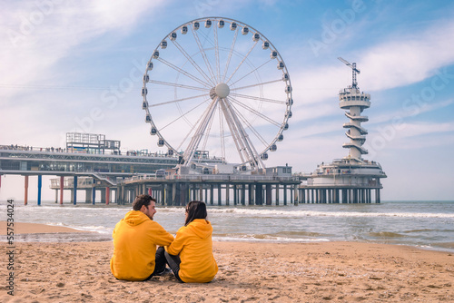 couple on the beach of Scheveningen Netherlands during Spring, The Ferris Wheel at The Pier at Scheveningen in the Netherlands, Sunny spring day at the beach of Holland