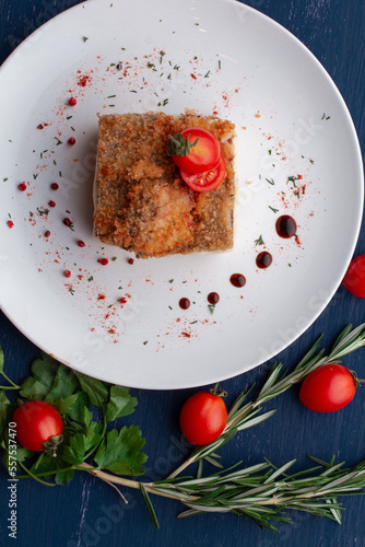 meat dish decorated with tomatoes and herbs