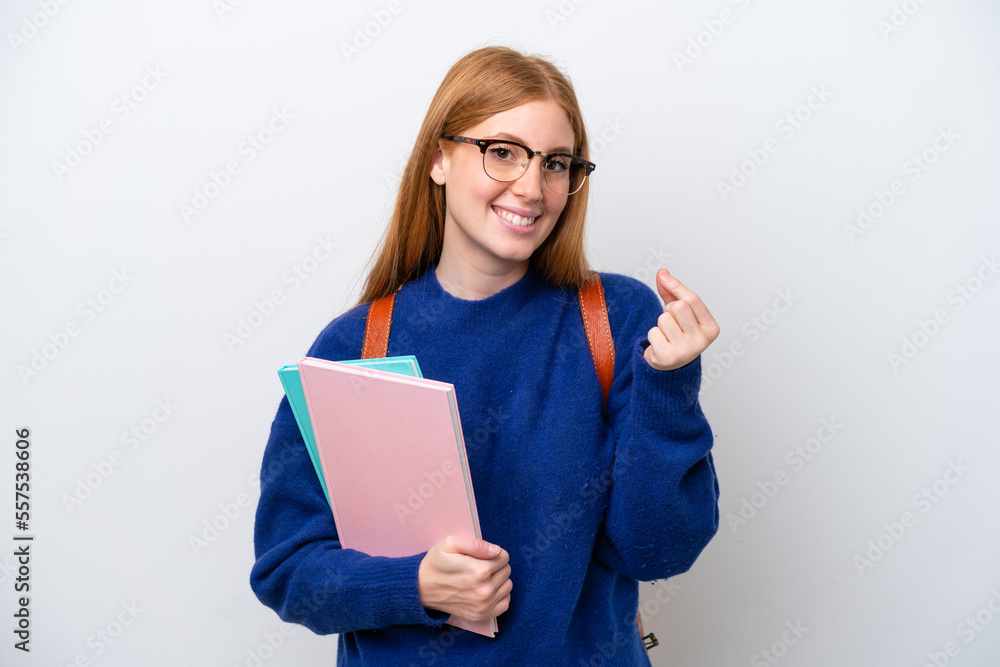 Young student redhead woman isolated on white background making money gesture Young student redhead woman isolated on white background making money gesture