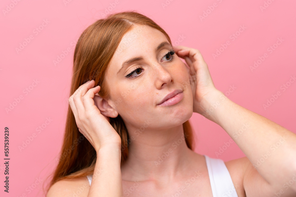 Young redhead woman isolated on pink background Young redhead woman isolated on pink background
