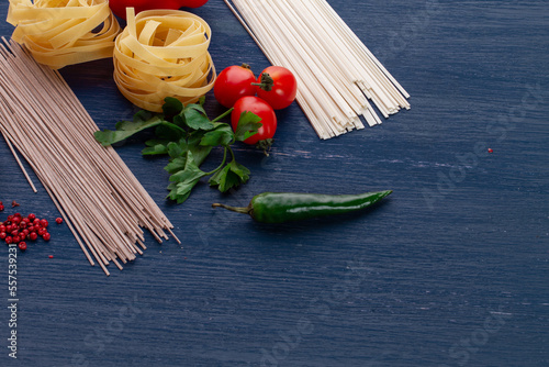 Pasta with vegetables on wood background. Ingredients for pasta