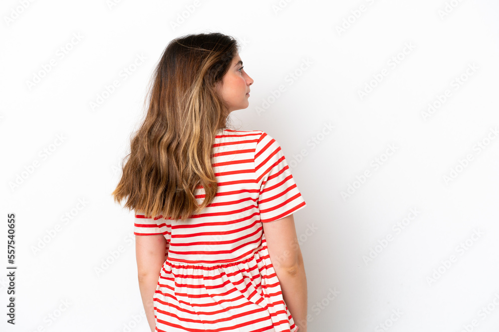 Young caucasian woman isolated on white background in back position and looking side Young caucasian woman isolated on white background in back position and looking side