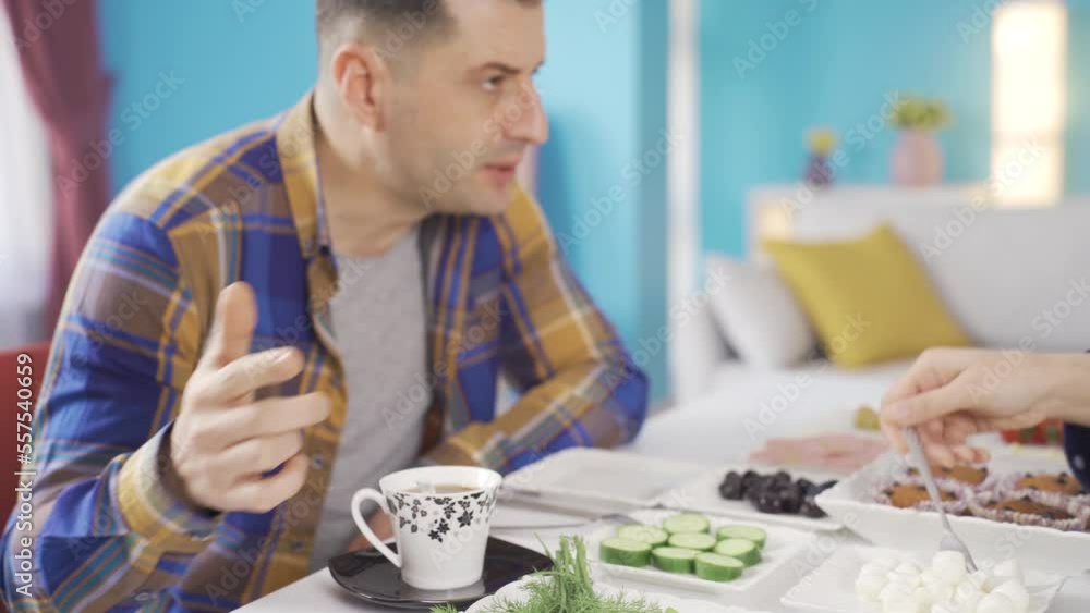Restless and unhappy married couple fighting each other at breakfast table in the morning. Restless and unhappy married couple fighting each other at breakfast table in the morning.