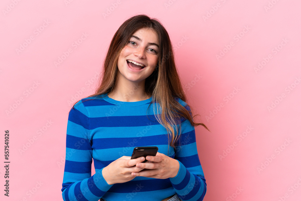 Young caucasian woman isolated on pink background surprised and sending a message Young caucasian woman isolated on pink background surprised and sending a message