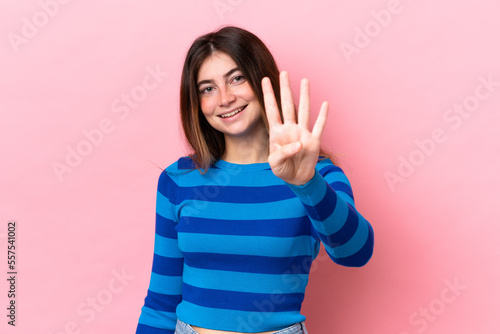 Young caucasian woman isolated on pink background happy and counting four with fingers
