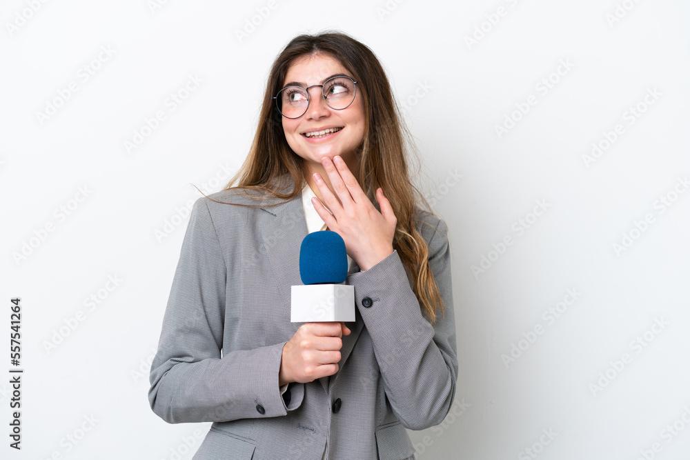 Young caucasian TV presenter woman isolated on white background looking up while smiling Young caucasian TV presenter woman isolated on white background looking up while smiling