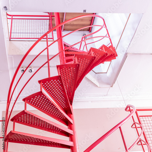 bright red isolated metal spiral staircase, with a white background