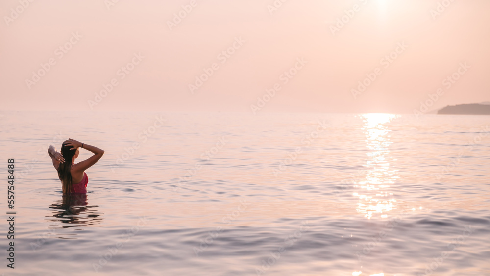 Attractive girl in swimsuit posing in the sea on sunset Attractive girl in swimsuit posing in the sea on sunset