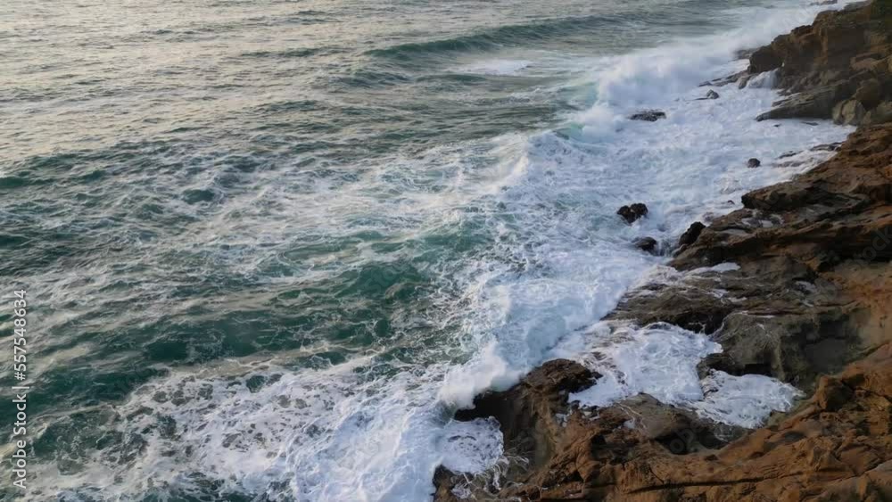 White ocean waves crash on a cliff before sunset White ocean waves crash on a cliff before sunset