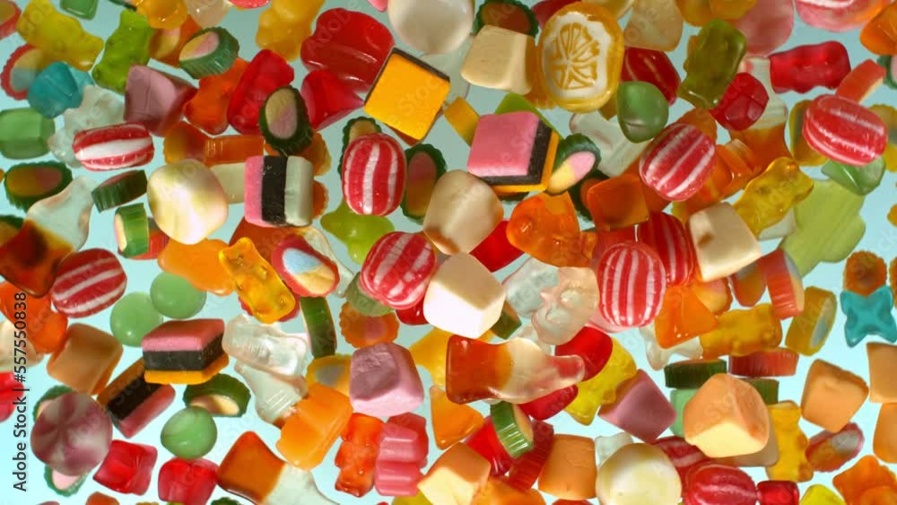 Sweet candies flying and rotating in slow motion against pastel background. Filmed on high speed cinema camera at 1000 fps. Sweet candies flying and rotating in slow motion against pastel background. Filmed on high speed cinema camera at 1000 fps.