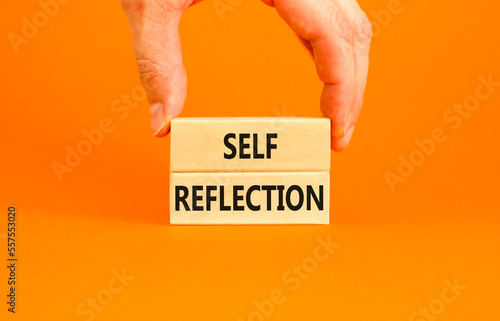 Self reflection symbol. Concept word Self reflection typed on wooden blocks. Beautiful orange table orange background. Businessman hand. Business psychological and self reflection concept. Copy space. photo