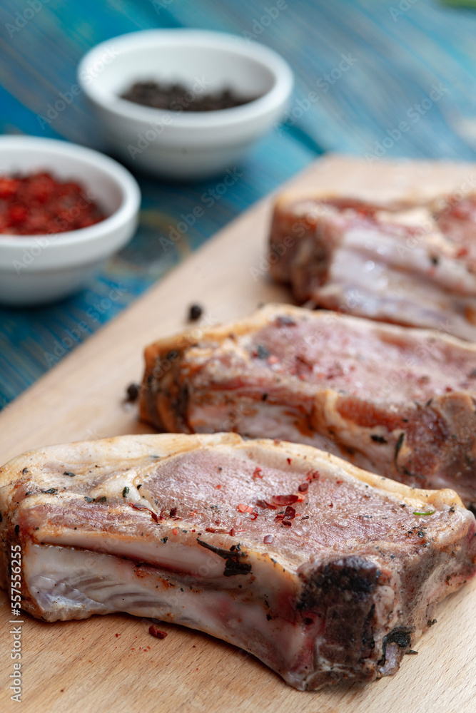 Fresh pork with ingredients for cooking on blue background