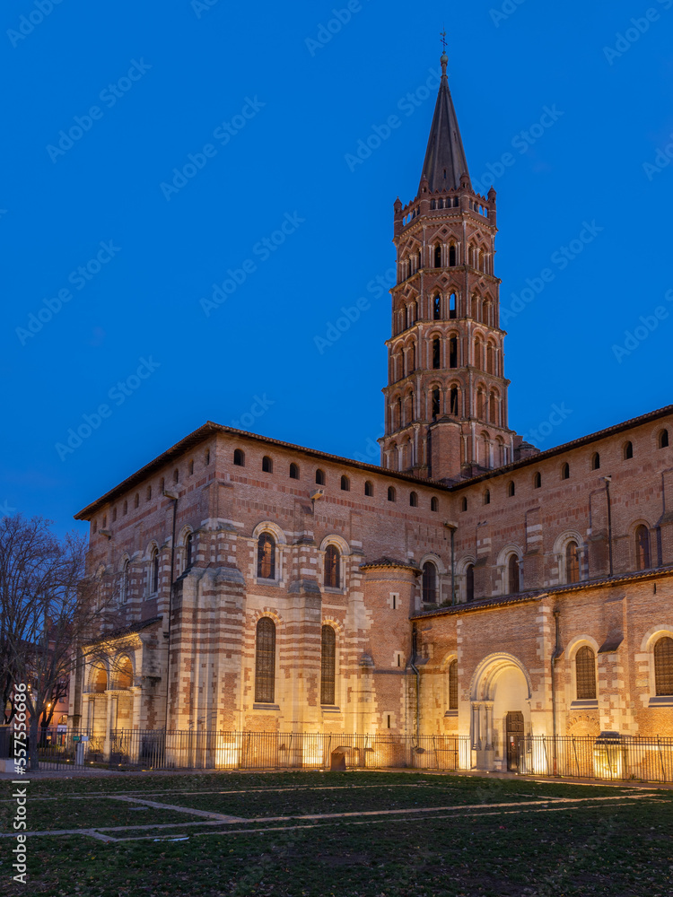 Vertical landscape view of famous landmark St Sernin basilica illuminated after sunset, Toulouse, France	
