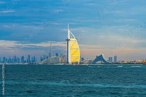 Obraz na plátně 30th Dec 2022 - Jumeirah, UAE: Burj Al Arab, the seven-star hotel with Burj Khalifa in the background during a cloudy sunset hour with the sun reflecting on the burj's windows