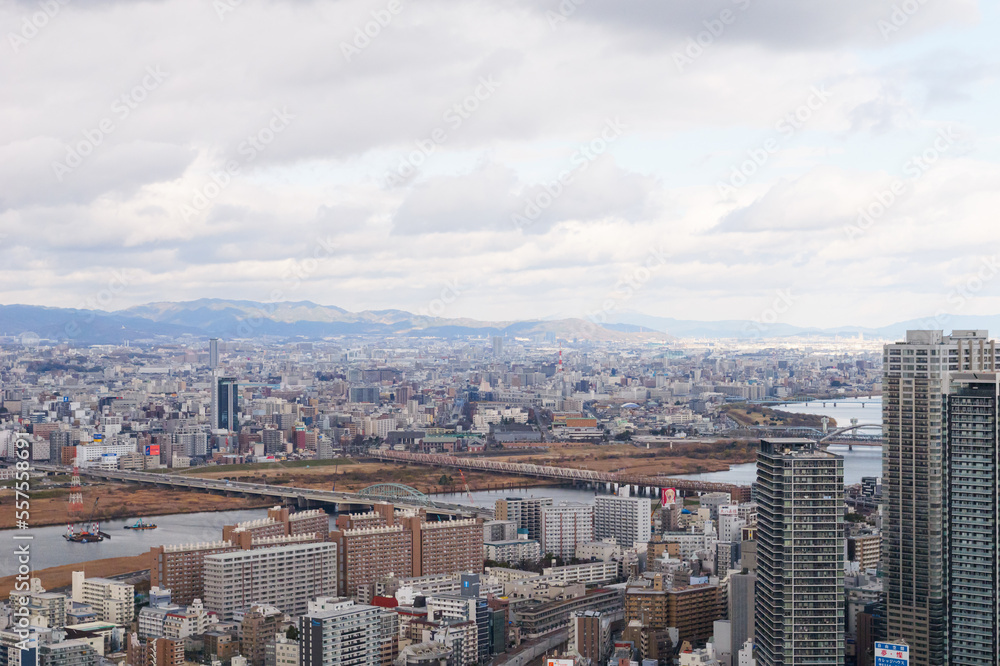 Obraz premium Overhead view of Osaka's Umeda area from a hill on a cloudy day