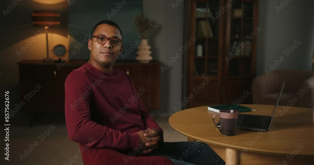 Latin man enjoys working online sitting at table with laptop Latin man enjoys working online sitting at table with laptop