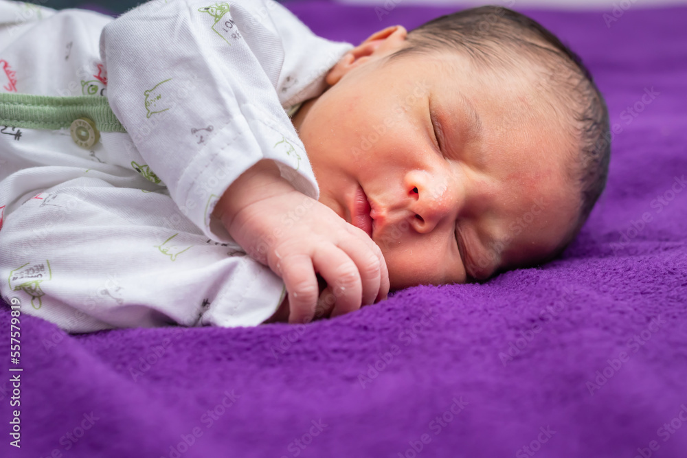 newborn baby isolated sleeping in white cloth with purple background from different angle newborn baby isolated sleeping in white cloth with purple background from different angle