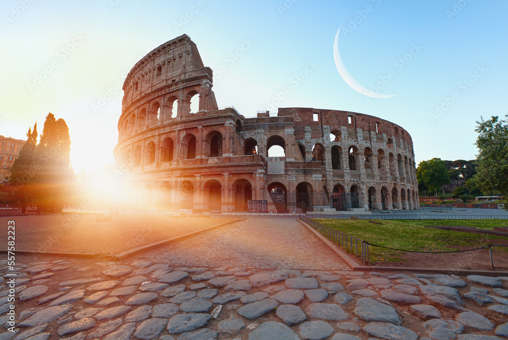 Fototapeta premium Colosseum in Rome with crescent moon at amazing sunrise - Colosseum is the best famous known architecture and landmark in Rome, Italy