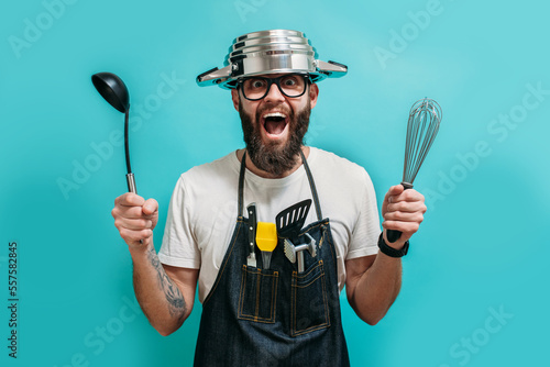 Funny bearded crazy chef with a pan on his head. Cooking. Crazy emotions