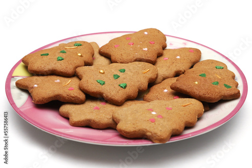 Homemade cookies in the form of a Christmas tree and a star in a plate on a white background. Close-up photo