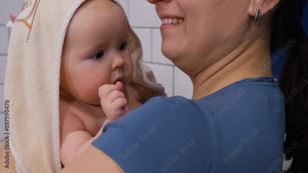 Young mother holding her cute baby after bathing at home. Hygiene procedures for infant and lifestyle concept Young mother holding her cute baby after bathing at home. Hygiene procedures for infant and lifestyle concept