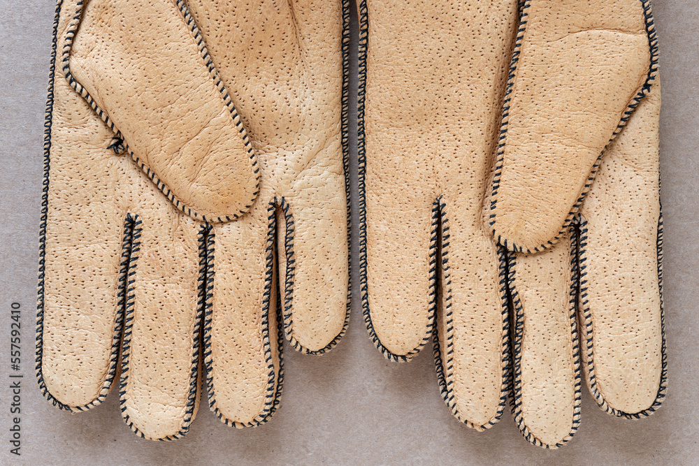 Fototapeta premium pig skin gloves in cork coloration on plain brown cardboard (palm side)