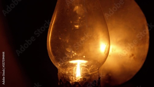 Close up of kerosene oil lamp lighting in dark room.