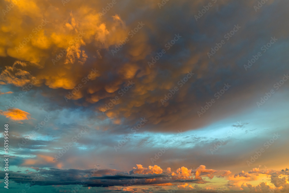 Obraz premium Cumulonimbus clouds forming before thunderstorm on evening sky. Changing stormy cloudscape weather at sunset