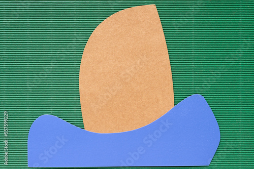 yellow and blue paper shapes on green cardboard with texture
