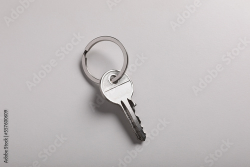 House key on light grey background, top view. Real estate agent services