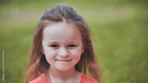 Portrait of a 6-year-old girl in a park in the summer.